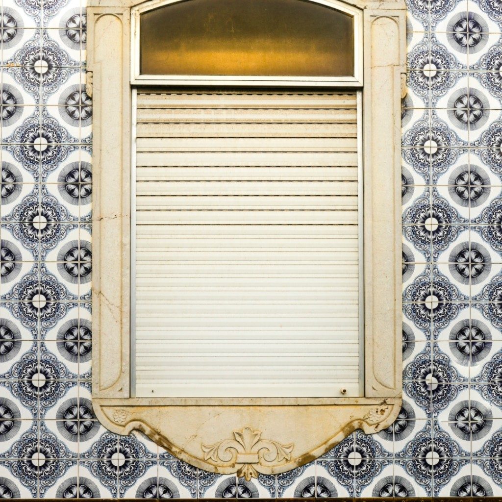 Estore exterior fechado numa fachada de azulejos em Lisboa