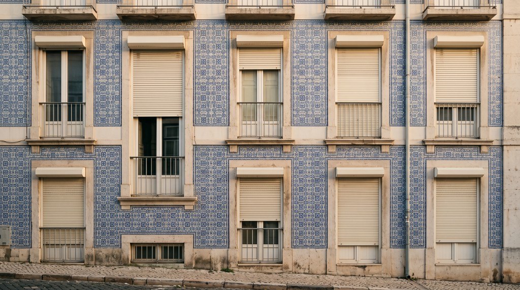 Estores de lâminas numa fachada de azulejos em Lisboa